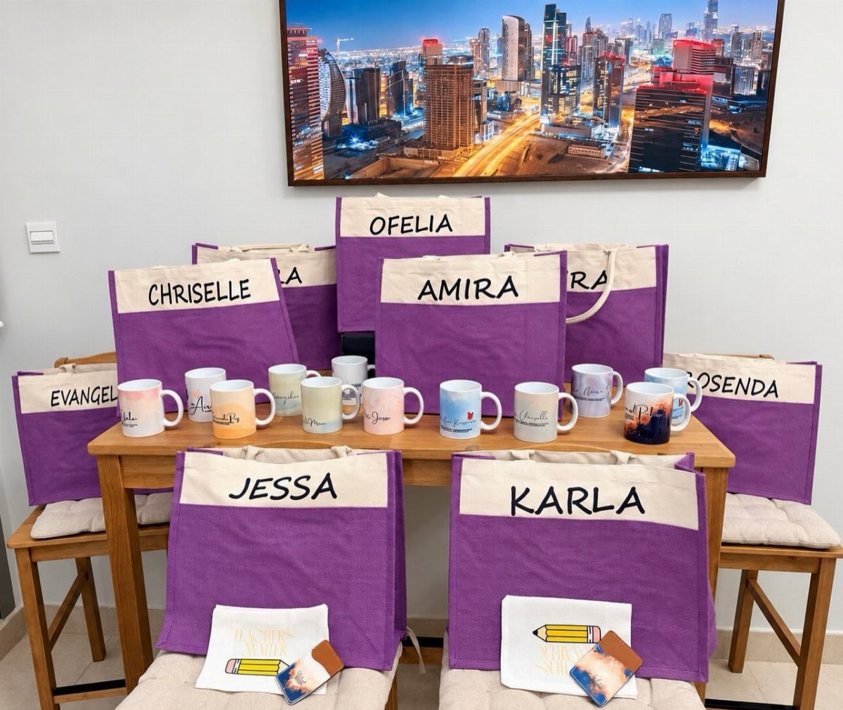 Personalized purple tote bags and ceramic mugs arranged on a wooden table.