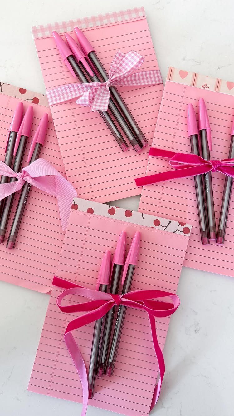 Pink lined notepads tied with ribbons and pink pens as teacher gifts.