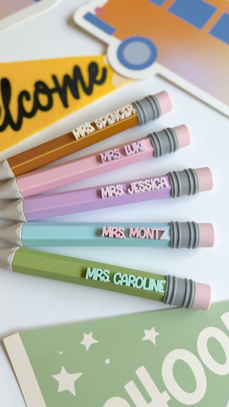 Five colorful personalized pencil pens with teacher names on a white background.