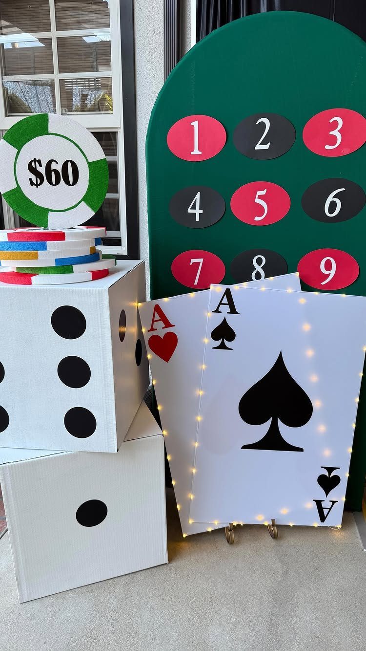 Casino decorations featuring giant dice, playing cards, and a large poker chip.
