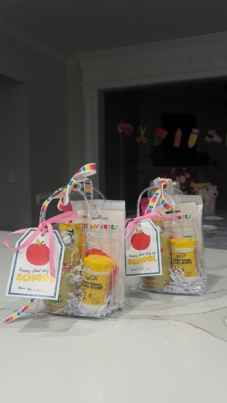 Two clear gift bags for teachers with apple tags and yellow wipes.