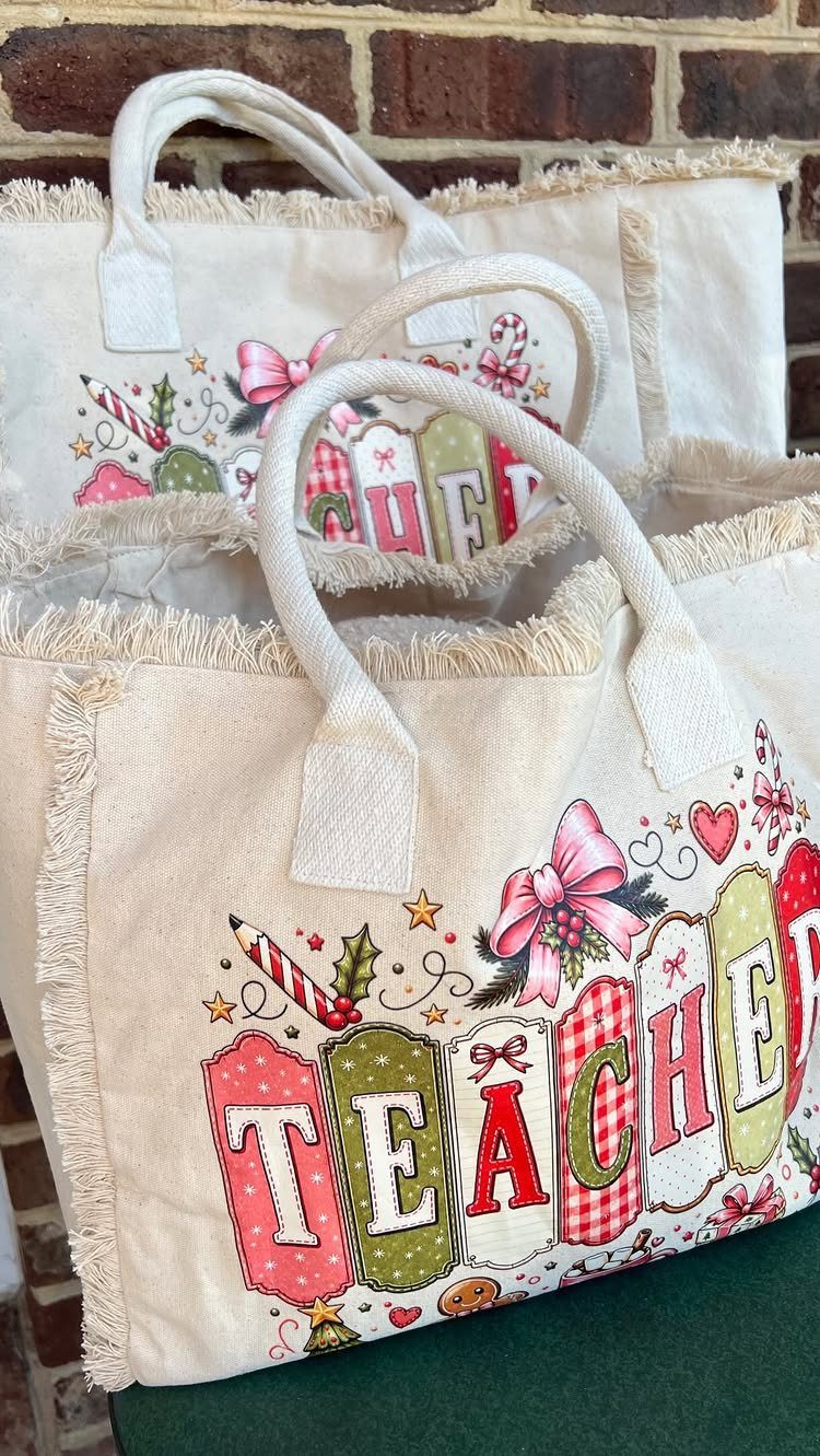 Canvas tote bags with a colorful teacher graphic and frayed edges against brick.